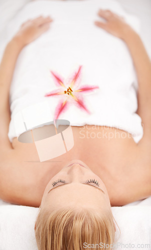 Image of Relax, massage and woman at spa with flower for luxury holistic treatment, facial health and sleep in towel. Self care, peace and refresh for girl on bed in natural rest for body wellness from above