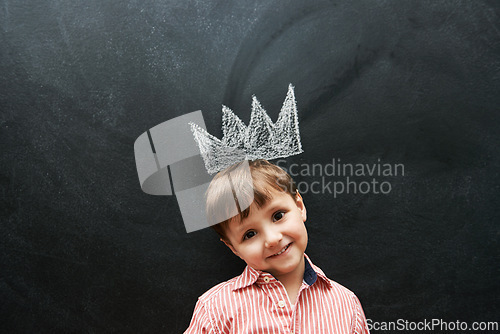 Image of Little boy, portrait and crown on chalkboard in black background and smile for school in elementary class. Kid, happiness and education for development of learner, blackboard and cute drawing