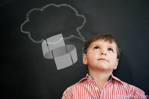 Image of Boy, standing and blackboard of thought bubble by student as drawing in preschool for imagination. Young child, happy and learning in classroom for education in art for development of creativity