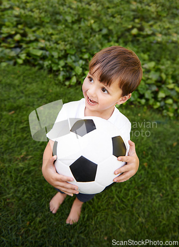 Image of Soccer, ball and excited child in garden for game, playing and fun on grass at home. Smile, happiness and boy with football, growth and development in backyard for sports for healthy children.