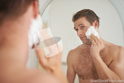 Image of Mirror, skincare and man with shaving cream application in a bathroom for morning, routine or hygiene. Hair removal, foam and male person in a house with facial product for beauty, wellness or care