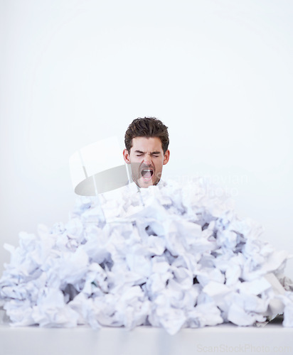 Image of Man, desk and frustrated with pile of paperwork, crisis and tired with burnout, stress and administration. Debt, bills and person lost in documents, overworked and overwhelmed with pressure in office