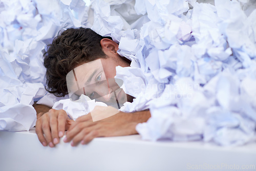 Image of Man, desk and tired with pile of paperwork, crisis and report with burnout, stress and administration. Fatigue, audit and person lost in documents, overworked and overwhelmed with pressure in office.