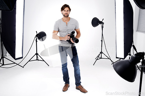 Image of Photographer, portrait or lighting with camera in studio for career, behind the scenes or confidence. Photography, guy and equipment with electronics, flash or shooting gear for photoshoot or passion