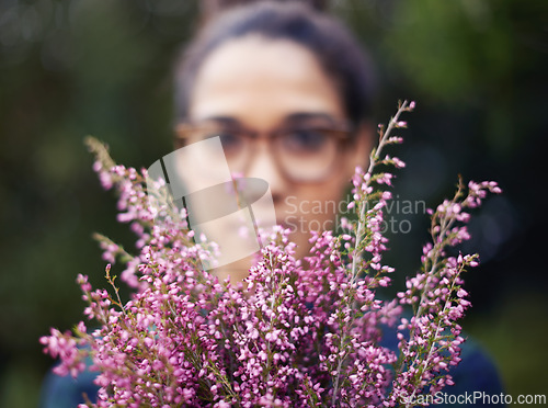 Image of Woman, face and flowers as gift outdoor in nature for gardening in spring and plant for harmony. Peace, backyard and home to calm person with present of fresh bouquet in purple to relax and enjoy