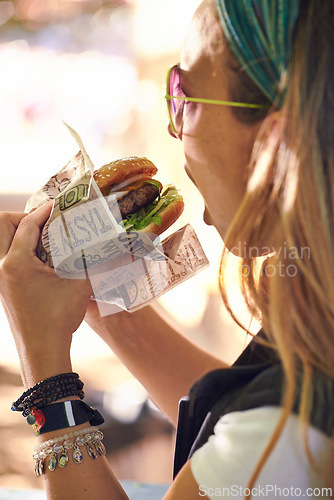 Image of Face, fast food and woman eating burger closeup outdoor for hunger, takeaway or craving in summer. Hamburger, lunch or snack with head of hungry young person biting a beef bun for cuisine or meal