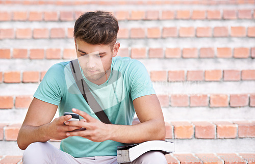 Image of Phone, university and man on steps with books for learning, studying and knowledge at college. Education, relax and student on cellphone typing for online chat, social media and networking at school