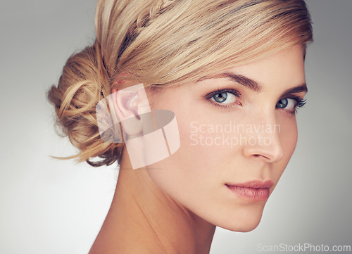 Image of Portrait, young woman and beauty face with skin glow of model. Female person, natural and with makeup, cosmetics and blonde hair against grey background with haircare and skincare for natural shine