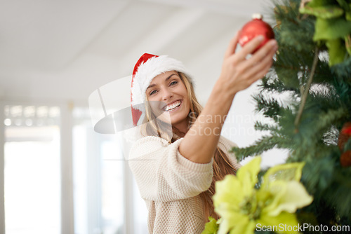 Image of Woman, portrait and tree decoration for Christmas with smile, fun and excited in home. Festive, xmas decor and girl with ornament, Santa hat and happy December holiday event in apartment living room.