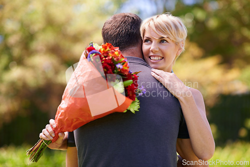 Image of Hug, happy couple and gift of flowers outdoor in nature, bonding and date on valentines day. Bouquet, man and woman embrace with present for love, care and romantic connection at garden together