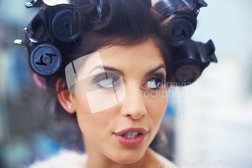 Image of Woman, face and hair curlers with makeup for beauty in salon with haircare, self care or cosmetology. Model, person or hairstyle for morning routine, curling or getting ready for wellness or grooming