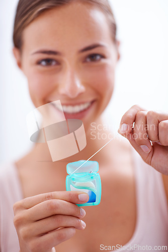 Image of Portrait, smile and dental floss for oral hygiene care with woman in bathroom of home for teeth whitening. Face, product and happy young person in apartment to prevent tooth decay or gum disease