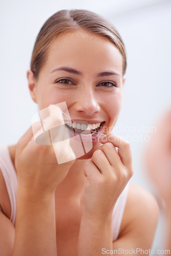 Image of Portrait, mouth and dental floss for oral hygiene care with woman in bathroom of home for teeth whitening. Face, product and face of young person in apartment to prevent tooth decay or gum disease