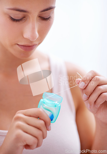 Image of Dental, health and woman with floss in studio for health, wellness and oral hygiene routine. Treatment, mouth and young female person with product for cleaning teeth isolated by white background.