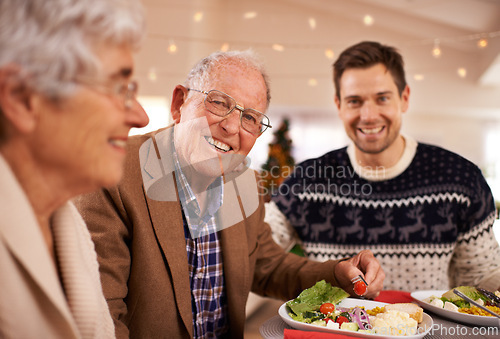 Image of Grandfather, portrait and family at dinner on Christmas together with food and celebration in home. Happy, event and old man smile with plate at lunch and relax on holiday at table with people