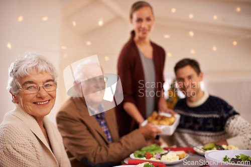 Image of Grandmother, portrait and family at dinner on Christmas, together with food and celebration in home. Happy, event and people smile with lunch, dish and relax on holiday at table with grandparents