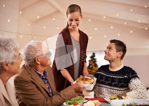 Image of Family, dinner and smile at table on Christmas, together with food and celebration in home. Senior, mother and father with happiness at lunch with woman hosting holiday and dish of chicken on plate