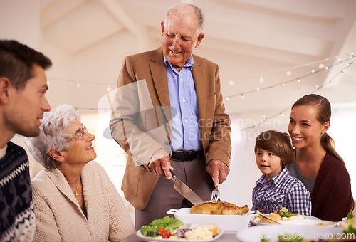 Image of Christmas, big family or eating lunch in home, smile or bonding together at party. Xmas, food or grandparents, parents and kid at table for festive celebration on holiday with grandpa cutting chicken