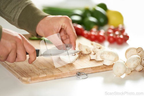 Image of Diet, cooking and hands cutting mushroom on kitchen counter with salad, wellness and nutrition in home. Board, knife and healthy food with vegetables at brunch, chef and vegan meal prep in apartment