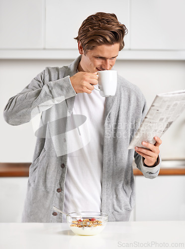 Image of Coffee, breakfast and man with newspaper in kitchen for information at modern apartment. Nutrition, cereal and young male person drinking cappuccino or latte and reading journalism article at home.