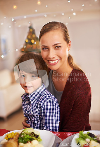 Image of Mother, child and portrait with Christmas dinner for celebration, smile and bond over festive season. Parent, kid and together with meal for celebration, xmas and holiday with food for family