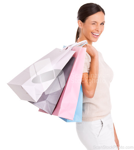 Image of Wink, shopping and portrait of woman on a white background with bag for sale, discount and deal. Excited, happy customer and isolated person for retail, consumerism and fashion purchase in studio