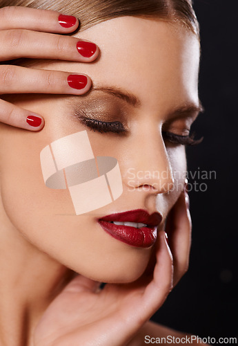 Image of Face, makeup and woman for beauty, hand for manicure and red nail polish, lipstick and eyeshadow with lashes on black background. Skin, foundation and shine, color for cosmetics and glamour in studio