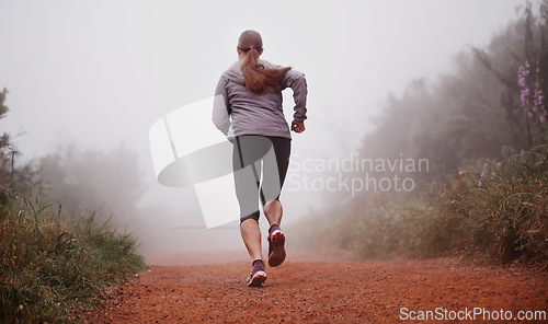 Image of Woman, rear view and running in woods with fitness for exercise, morning routine and workout with fog and legs. Athlete, person and cardio with sportswear on outdoor trail and forest for wellness
