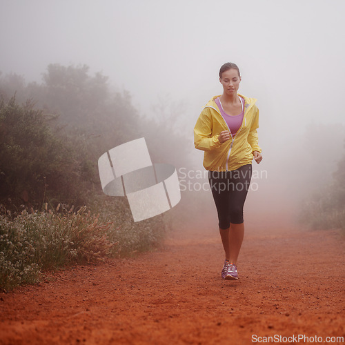 Image of Woman, health and running in forest with fitness for exercise, morning routine and workout with fog and confidence. Athlete, person and cardio with sportswear on outdoor trail and woods for wellness