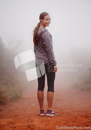 Image of Woman, portrait and hiking in forest with fog for exercise, morning routine and workout with fitness and smile. Athlete, face and person with happiness on mountain trail for wellness and healthy body