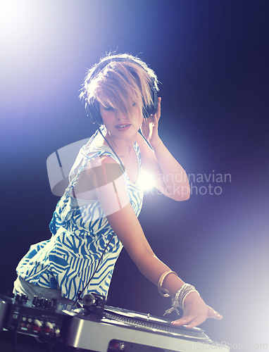 Image of Woman, dj and turntable with headphones for mixing on stage for concert, music and gig at rave party for entertainment. Female sound mixer, artist and musician with record player for playlist