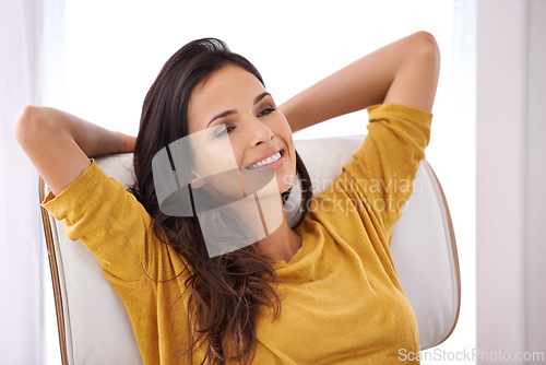 Image of Woman, relax and smile on work break in a chair in a home with rest and calm in a lounge with rest. Happy, chill and female creative freelancer and idea in the morning sitting with peace and thinking