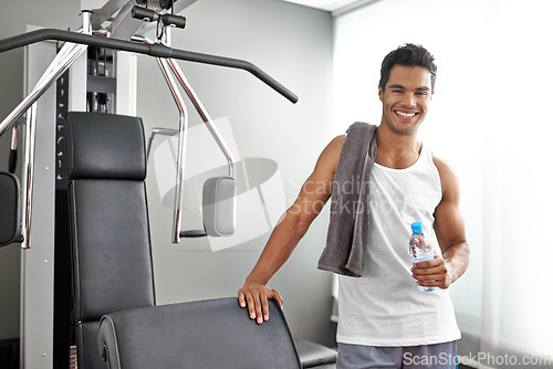 Image of Happy, portrait and man at gym with water bottle for recovery after exercise for body building. Healthy, fitness and person relax after workout with hydration for benefits to wellness in Mexico