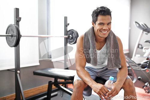 Image of Happy, man and portrait at gym with water bottle for recovery after exercise and body building. Healthy, fitness or person relax after workout with liquid hydration for benefits to wellness in Mexico