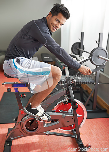 Image of Fitness, bicycle and portrait of man in gym for cycling marathon, race or competition training. Fitness, health and athlete riding spinning machine for cardio workout or exercise in sports center.