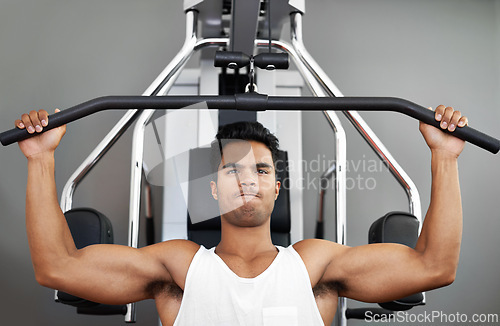 Image of Fitness, pull down machine and man in studio on gray background for training or workout at gym. Exercise, health or shoulder press and body builder with equipment for wellness, strength or power