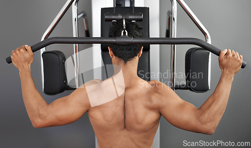 Image of Exercise, pull down machine and man in studio on gray background for training or workout at gym. Back, health or shoulder press and body builder with equipment for wellness, strength or power