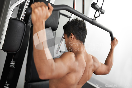 Image of Exercise, pull down machine and man in studio on gray background for training or workout at gym. Fitness, health or shoulder press and body builder with equipment for wellness, strength or power