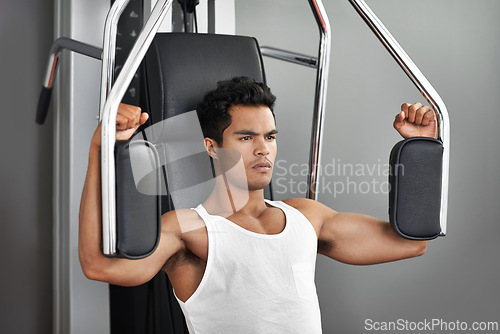 Image of Fitness, resistance exercise and man in gym for arm muscle training for health, wellness and strength. Active, body and young male athlete on machine with weights for bodybuilding in sports center.