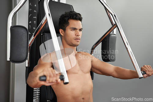 Image of Workout, resistance exercise and man in gym for arm muscle training for health, wellness and strength. Active, body and young male athlete on machine with weights for bodybuilding in sports center.