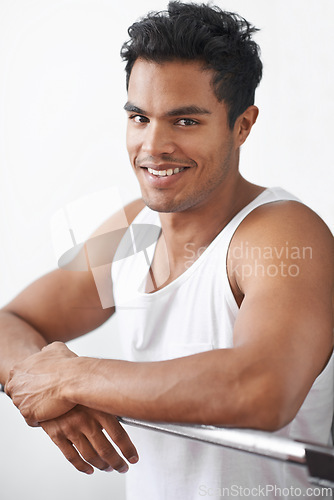Image of Happy, fitness and portrait of man at gym in studio for body workout or muscle training. Smile, sports and young male athlete at steel bar for health or wellness exercise by white background.