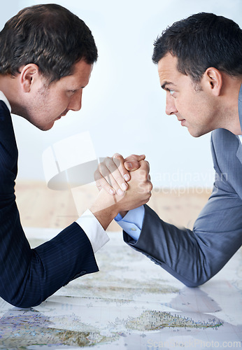 Image of Businessman, handshake and arm wrestle for competition, challenge or strength on table at the office. Serious man, corporate employees or business partners shaking hands for game, contest or battle