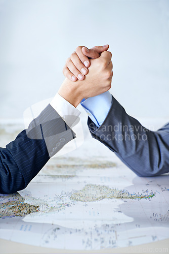 Image of Map, arm wrestle and power struggle with business people in studio for battle, competition or war. Hands, strategy or challenge with corporate employee and rival fighting for global domination