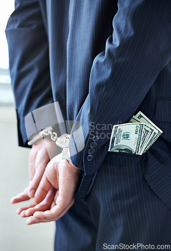 Image of Business person, hands and cash with handcuffs for bribe, secret or corruption in financial crime. Closeup or rear view of employee with pocket money, paper or laundering finance in bribery or fraud