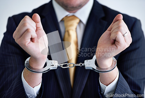 Image of Hands, person in corporate and handcuffs for fraud or bribery, business deal gone wrong with justice or jail. Professional crime, corruption or money laundering, shackles for prison with criminal