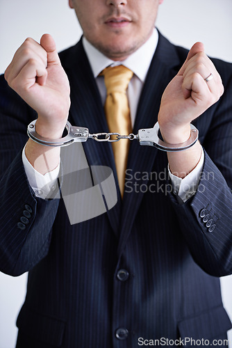 Image of Hands, business man and handcuffs for fraud or bribery, suspicious professional deal with justice or jail. Crime, corruption or money laundering, shackles for prison with thief or criminal in finance