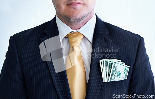 Image of Suit, serious and businessman with money in pocket for bribe, fraud or financial scam in studio. Corruption, pay and closeup of professional male person with cash for crime by white background.