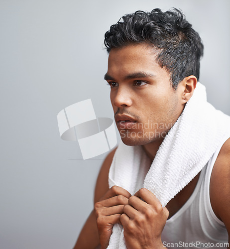 Image of Face, fitness and towel with man breathing in studio isolated on gray background for workout. Exercise, sweating and intensity with confident young athlete on break from training for performance