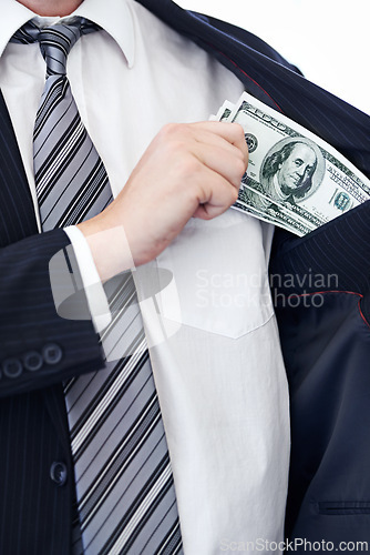 Image of Business person, hands and money bribe in pocket for fraud, scam or secret on a white studio background. Closeup of employee with cash, dollar bills or finance in bribery, deal or financial exchange