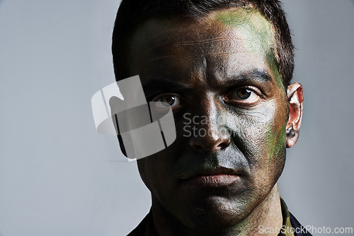 Image of Man, portrait and camouflage with face paint for war, battle or military service on a gray studio background. Closeup of male person, army or solider with color dye for undercover disguise on mockup